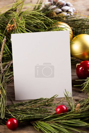Photo for Vertical image of christmas decorations, white card and copy space on wooden background. Christmas, decorations, tradition and celebration concept. - Royalty Free Image