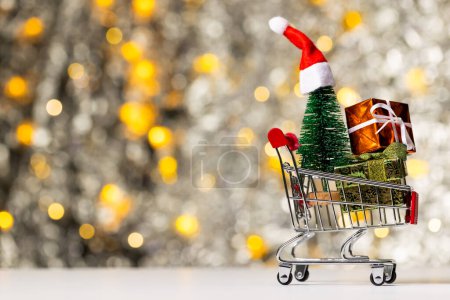 Photo for Shopping trolley with gifts and christmas fairy lights with copy space background. Christmas, decorations, tradition and celebration concept. - Royalty Free Image