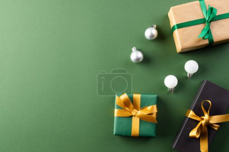 Téléchargez les photos : Cadeaux de Noël avec rubans, boules et espace de copie sur fond vert. Cadeaux, Noël, concept de tradition et de célébration. - en image libre de droit