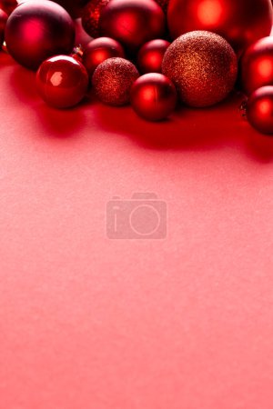 Téléchargez les photos : Image verticale des décorations de boules rouges de Noël avec espace de copie sur fond rouge. Noël, décorations, concept de tradition et de célébration. - en image libre de droit