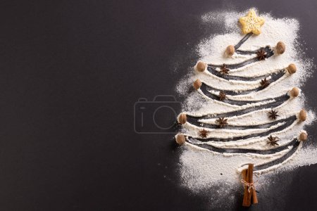 Foto de Galletas de Navidad y forma de árbol de Navidad en harina con espacio para copiar sobre fondo negro. Dulces, Navidad, tradición y concepto de celebración. - Imagen libre de derechos