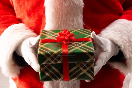Photo for Santa claus holding christmas present with copy space on black background. Santa claus, christmas, tradition and celebration concept. - Royalty Free Image