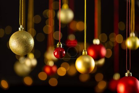 Téléchargez les photos : Boules de Noël rouges et dorées avec espace de copie sur fond noir. Noël, décorations, concept de tradition et de célébration. - en image libre de droit