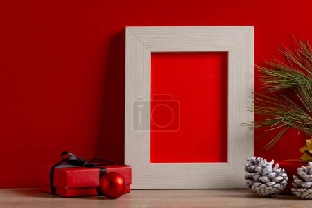 Téléchargez les photos : Décorations de Noël et cadre en bois avec espace de copie sur fond rouge. Noël, décorations, concept de tradition et de célébration. - en image libre de droit