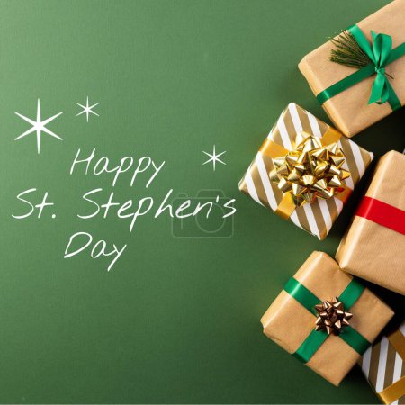 Photo for Composite of happy st stephen's day text and christmas presents on green background, copy space. Gift, surprise, saint, christian martyr, honor, commemorates, holiday and celebration concept. - Royalty Free Image