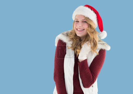 Foto de Retrato de mujer caucásica con sombrero de santa sonriendo contra el espacio de copia sobre fondo azul. concepto de navidad y festividad - Imagen libre de derechos