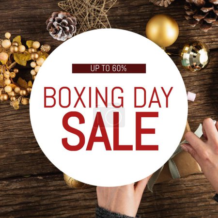 Photo for Composite of upto 60 percent boxing day sale text over caucasian hands wrapping gift boxes on table. Shopping, sale, discount, marketing, template, design, retail, advertise concept. - Royalty Free Image