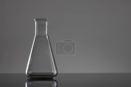 Foto de Cierre de vaso de precipitados de laboratorio y espacio de copia sobre fondo gris. Concepto de laboratorio, ciencia, investigación y química. - Imagen libre de derechos