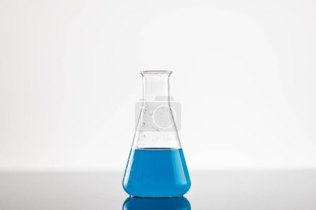 Photo for Close up of laboratory beaker with blue liquid and copy space on white background. Laboratory, science, research and chemistry concept. - Royalty Free Image
