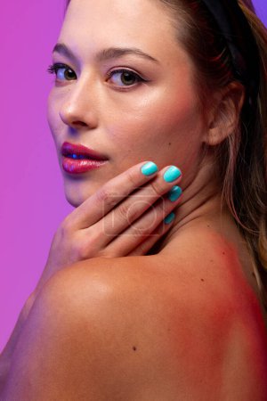 Photo for Portrait of caucasian woman wearing pink lipstick and blue nail polish on purple background. Cosmetics, makeup, female fashion and beauty, unaltered. - Royalty Free Image