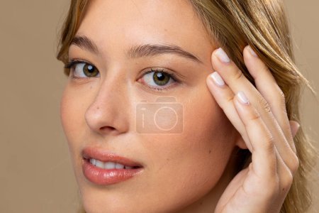 Photo for Portrait of caucasian woman wearing natural makeup and beige nail polish on beige background. Cosmetics, makeup, female fashion and beauty, unaltered. - Royalty Free Image