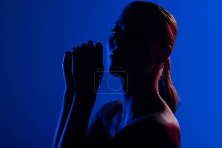 Foto de Retrato de mujer caucásica con brillo de labios sobre fondo azul. Cosméticos, maquillaje, moda femenina y belleza, inalterados. - Imagen libre de derechos