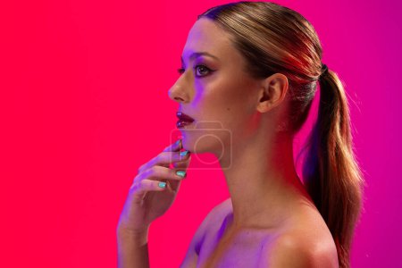 Photo for Caucasian woman wearing red lipstick and blue nail polish on pink background, copy space. Cosmetics, makeup, female fashion and beauty, unaltered. - Royalty Free Image