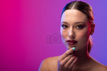 Foto de Retrato de mujer caucásica con esmalte de uñas azul sobre fondo púrpura, espacio para copiar. Cosméticos, maquillaje, moda femenina y belleza, inalterados. - Imagen libre de derechos