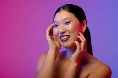Photo for Portrait of asian woman wearing blue eyeliner and red nail polish on purple background, copy space. Cosmetics, makeup, female fashion and beauty, unaltered. - Royalty Free Image