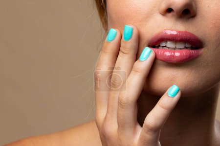 Photo for Caucasian woman wearing natural makeup and blue nail polish on beige background, copy space. Cosmetics, makeup, female fashion and beauty, unaltered. - Royalty Free Image