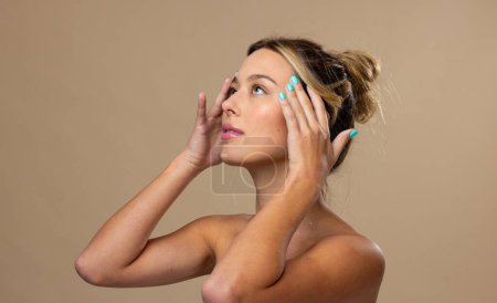 Photo for Caucasian woman wearing natural makeup and blue nail polish on beige background. Cosmetics, makeup, female fashion and beauty, unaltered. - Royalty Free Image