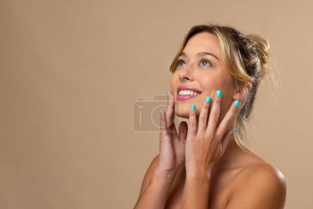 Téléchargez les photos : Femme blanche portant un maquillage naturel et vernis à ongles bleu sur fond beige, espace de copie. Cosmétiques, maquillage, mode féminine et beauté, inchangés. - en image libre de droit