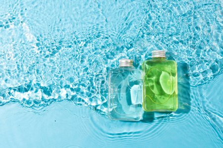 Photo for Beauty product bottles in water with copy space background on blue background. Health and beauty, make up and beauty concept. - Royalty Free Image