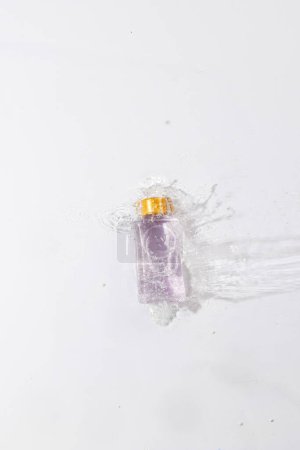 Photo for Vertical image of beauty product bottle in water with copy space background on white background. Health and beauty, make up and beauty concept. - Royalty Free Image