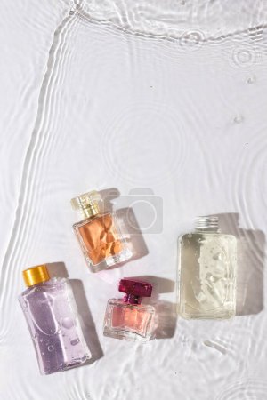 Photo for Vertical image of beauty product bottles in water with copy space background on white background. Health and beauty, make up and beauty concept. - Royalty Free Image