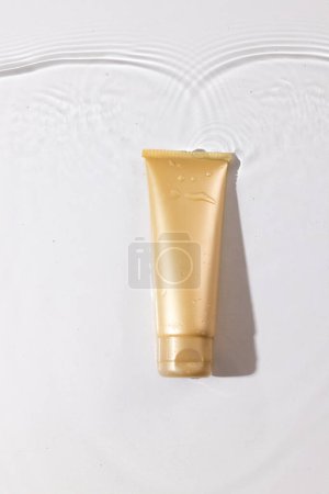 Photo for Vertical image of beauty product tube in water with copy space background on white background. Health and beauty, make up and beauty concept. - Royalty Free Image
