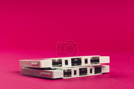 Téléchargez les photos : Gros plan de cassettes roses et blanches avec espace de copie sur fond rose. Concept de musique, son, écoute, divertissement et nostalgie. - en image libre de droit