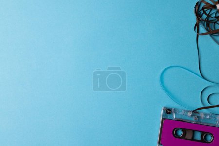Foto de Vista aérea de la cinta de casete púrpura con espacio de copia sobre fondo azul. Música, sonido, escucha, entretenimiento y concepto de nostalgia. - Imagen libre de derechos