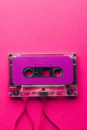 Foto de Vista aérea de cinta de casete púrpura con espacio para copiar sobre fondo rosa. Música, sonido, escucha, entretenimiento y concepto de nostalgia. - Imagen libre de derechos