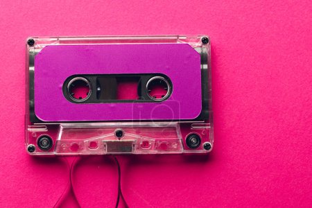 Téléchargez les photos : Vue aérienne de la cassette violette sur fond rose. Concept de musique, son, écoute, divertissement et nostalgie. - en image libre de droit