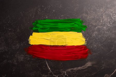 Photo for Green, yellow and red paints with copy space on black stone background. Black history month, africa, black culture and history concept. - Royalty Free Image