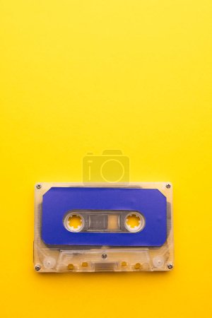 Téléchargez les photos : Vue aérienne de la cassette bleue avec espace de copie sur fond jaune. Concept de musique, son, écoute, divertissement et nostalgie. - en image libre de droit