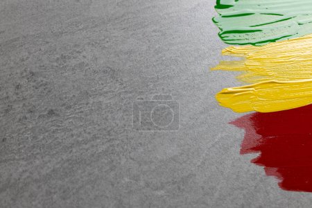 Photo for Green, yellow and red paints with copy space on grey stone background. Black history month, africa, black culture and history concept. - Royalty Free Image