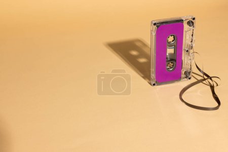 Photo for Close up of purple cassette tape with copy space on beige background. Music, sound, listening, entertainment and nostalgia concept. - Royalty Free Image