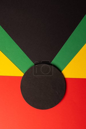 Téléchargez les photos : Image verticale de papiers verts, jaunes et rouges avec cercle noir et espace de copie sur fond noir. Mois de l'histoire des Noirs, Afrique, culture noire et concept d'histoire. - en image libre de droit