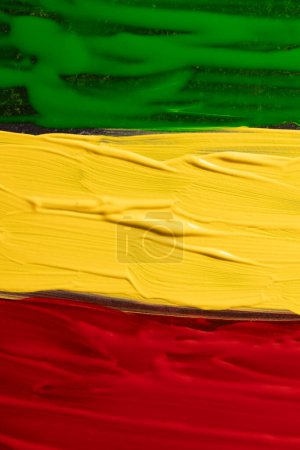 Photo for Vertical image of green, yellow and red paints with copy space background. Black history month, africa, black culture and history concept. - Royalty Free Image