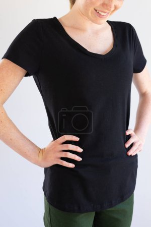 Photo for Vertical image of smiling caucasian woman in black t-shirt and copy space on white background. Clothes, fashion and casual clothes concept, unaltered. - Royalty Free Image