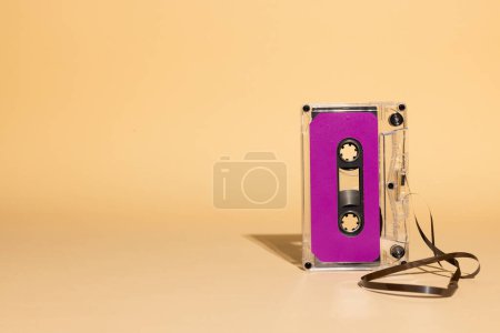 Téléchargez les photos : Gros plan de cassette violette avec espace de copie sur fond beige. Concept de musique, son, écoute, divertissement et nostalgie. - en image libre de droit