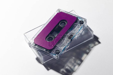Photo for Close up of purple cassette tape and white box on white background. Music, sound, listening, entertainment and nostalgia concept. - Royalty Free Image