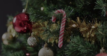 Foto de Un árbol de Navidad adornado con decoraciones festivas. Los adornos y el oropel agregan un ambiente acogedor de las vacaciones al ajuste casero. - Imagen libre de derechos
