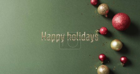Téléchargez les photos : Joyeux texte de vacances avec des boules de Noël pailletées sur fond vert. Noël, décorations, tradition, salutations et célébration image générée numériquement. - en image libre de droit