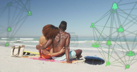 Foto de Imagen de redes giratorias con iconos digitales de redes sociales sobre parejas abrazándose en la playa. interfaz digital, redes sociales y concepto de red global imagen generada digitalmente. - Imagen libre de derechos