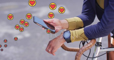 Foto de Múltiples iconos del corazón flotando contra la mitad de la sección de la mujer con bicicleta usando smartphone. concepto de redes sociales y tecnología - Imagen libre de derechos