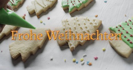 Photo for Frohe weihnachten text in orange over decorated christmas cookies on white background. Christmas, tradition, german, greetings and celebration digitally generated image. - Royalty Free Image