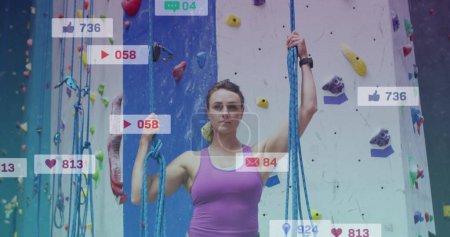 Photo for Image of media icons over caucasian woman on climbing wall. health and fitness concept digitally generated image. - Royalty Free Image