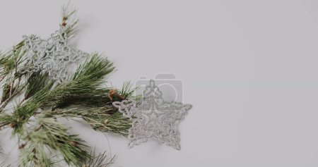 Téléchargez les photos : Un ornement de flocon de neige argenté repose à côté des branches de pin, avec espace de copie. Évoquant l'esprit des fêtes, l'image est idéale pour les thèmes de la saison des fêtes et les idées de décoration de Noël. - en image libre de droit