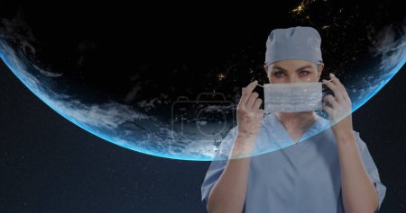 Téléchargez les photos : Portrait de chirurgienne portant un masque facial sur fond bleu. traitement médical et concept de technologie - en image libre de droit