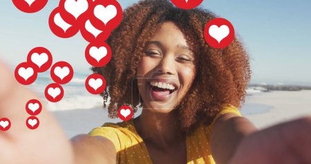 Foto de Joven mujer afroamericana captura un selfie al aire libre, con espacio para copias. Su expresión alegre está rodeada de corazones flotantes, sugiriendo un tema de amor o felicidad. - Imagen libre de derechos