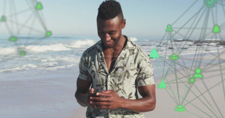 Photo for Image of spinning networks with social media digital icons over man using smartphone on beach. digital interface, social media and global networking concept digitally generated image. - Royalty Free Image