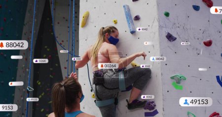 Foto de Múltiples burbujas de voz con iconos digitales contra la mujer caucásica en forma escalada en la pared en el gimnasio. concepto de tecnología de redes deportivas, fitness y redes sociales - Imagen libre de derechos